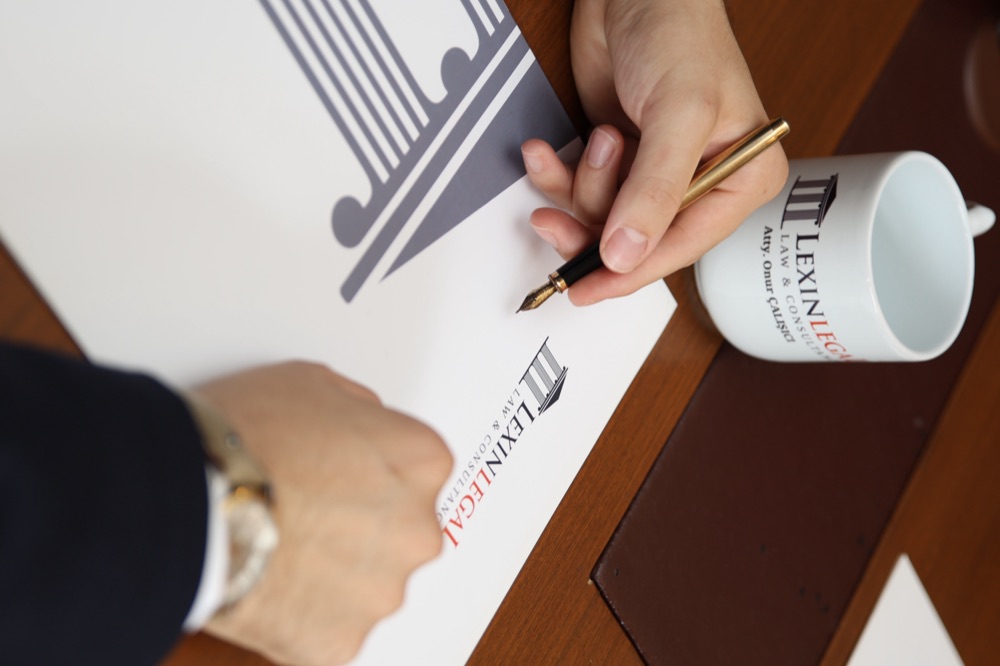 A Lexin Legal lawyer signing a document on the firm's branded letterhead