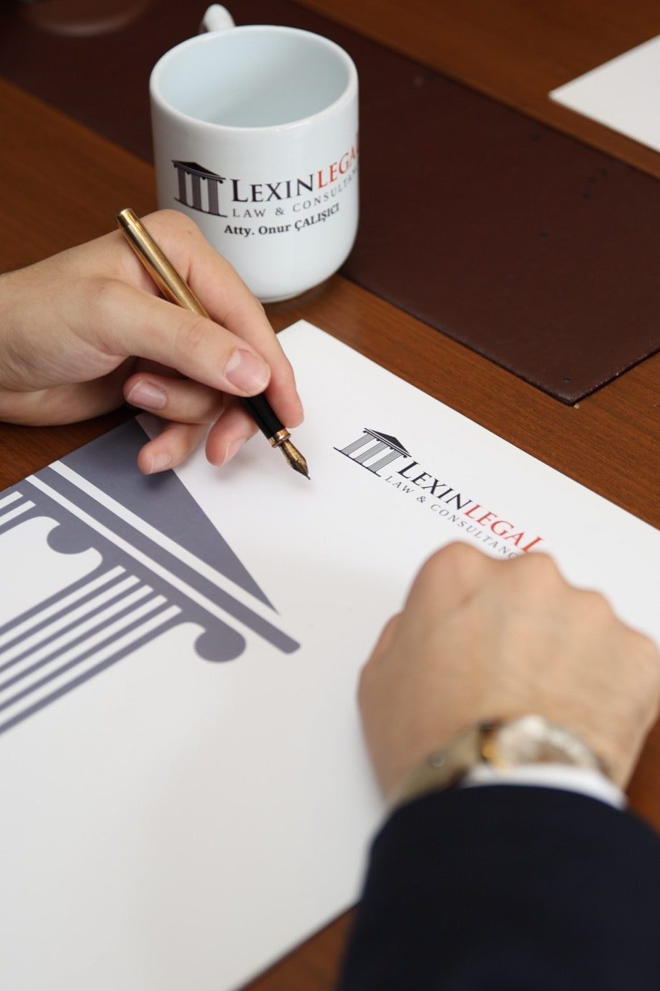 A Lexin Legal lawyer signing a document on the firm's branded letterhead